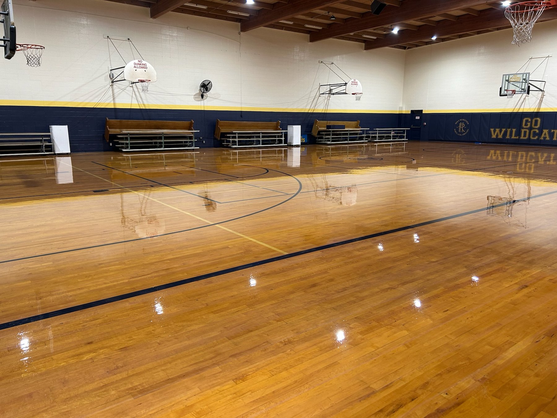 Refinished hardwood gymnasium floor with mirror gloss and crisp game lines in Portland, Oregon